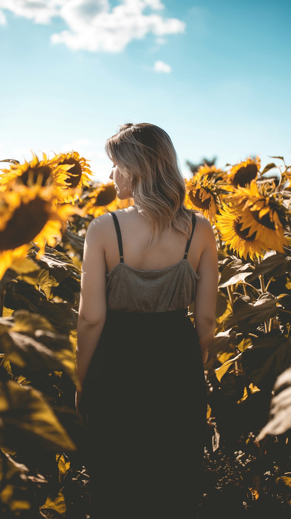 a woman standing in a field of sunflowers