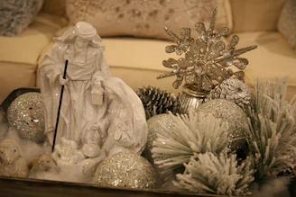 A snowy winter-themed nativity with white trees and soft cotton snow around the figures.
