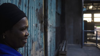 Portrait of Kamruzzaman smiling warmly in an industrial setting with steel plant background.
