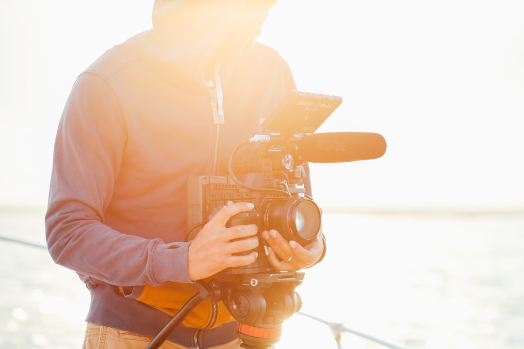 man in jacket holds camera