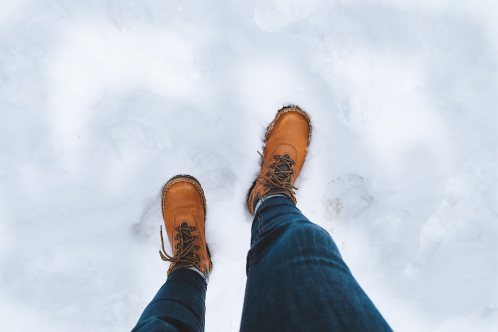 man wearing brown boots walking in icy surface