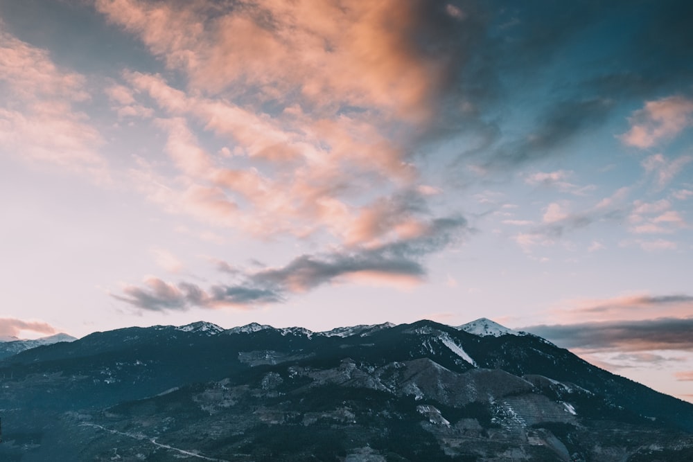 photo de paysage de montagne sous ciel nuageux pendant la journée