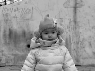 Editorial style image of a child wearing a full set with abstract and holiday-themed patches against a neutral background.
