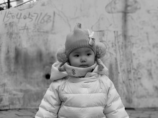 Editorial style image of a child wearing a full set with abstract and holiday-themed patches against a neutral background.