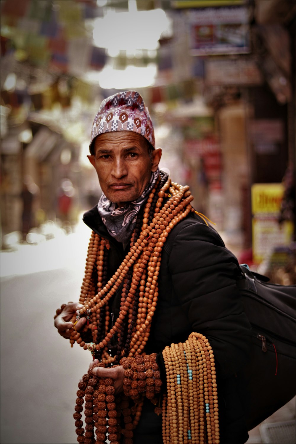 man carrying brown beads while walking on street