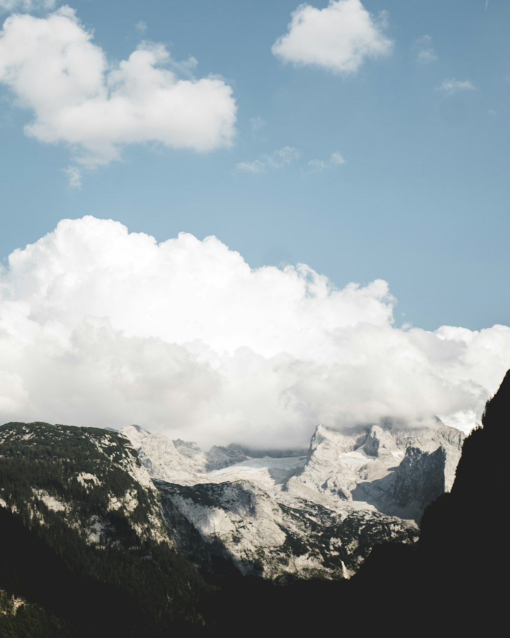 landscape photo of snow covered mountains under cloudy sky