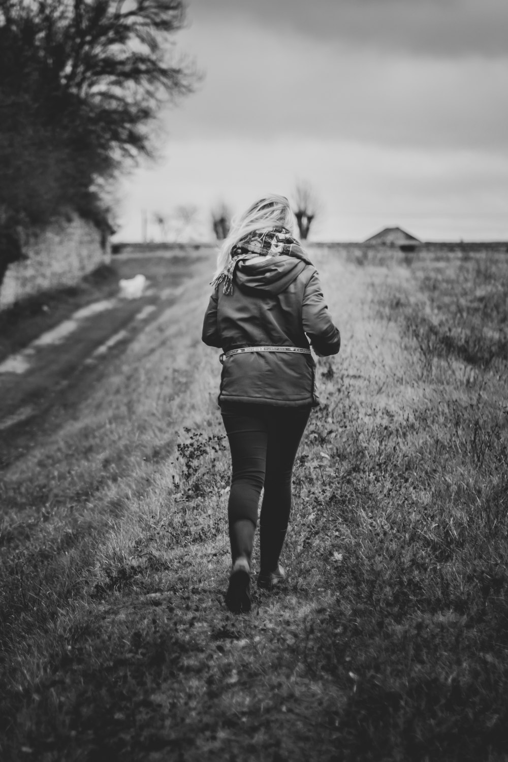gray scale photography of woman about to run wearing hoodie