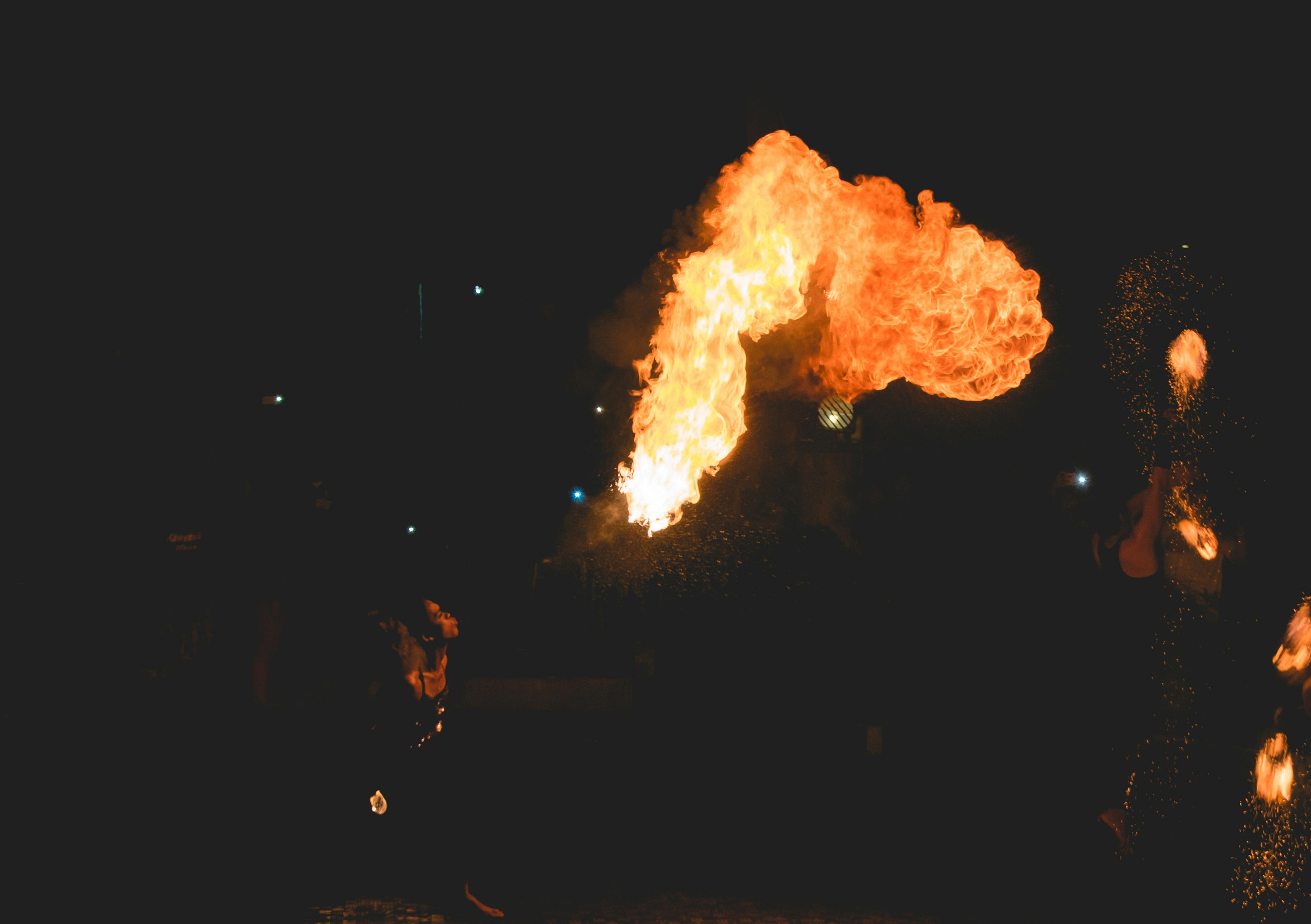 A firebreather blows a huge plume of flame into the night sky.