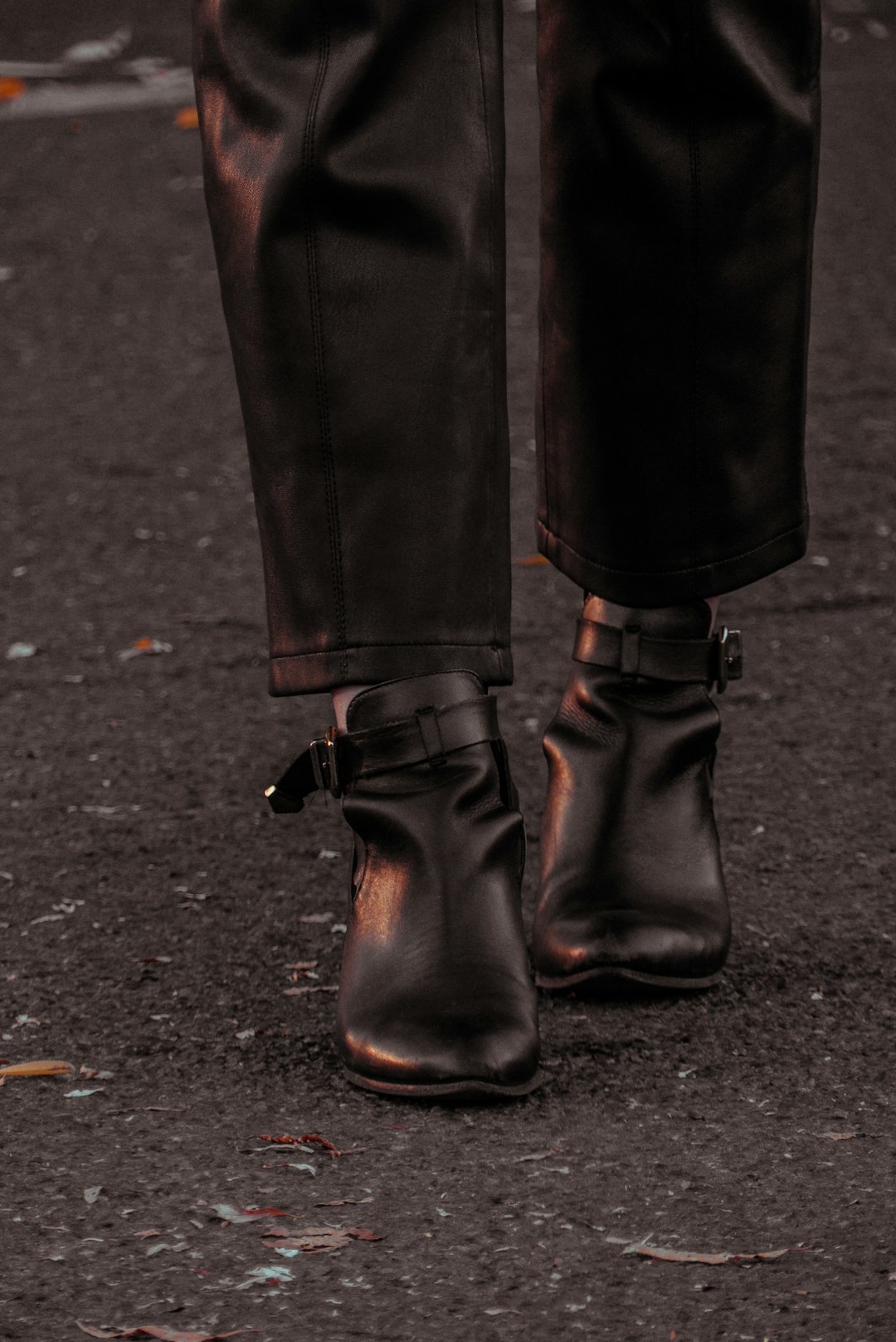 person wearing black leather boots