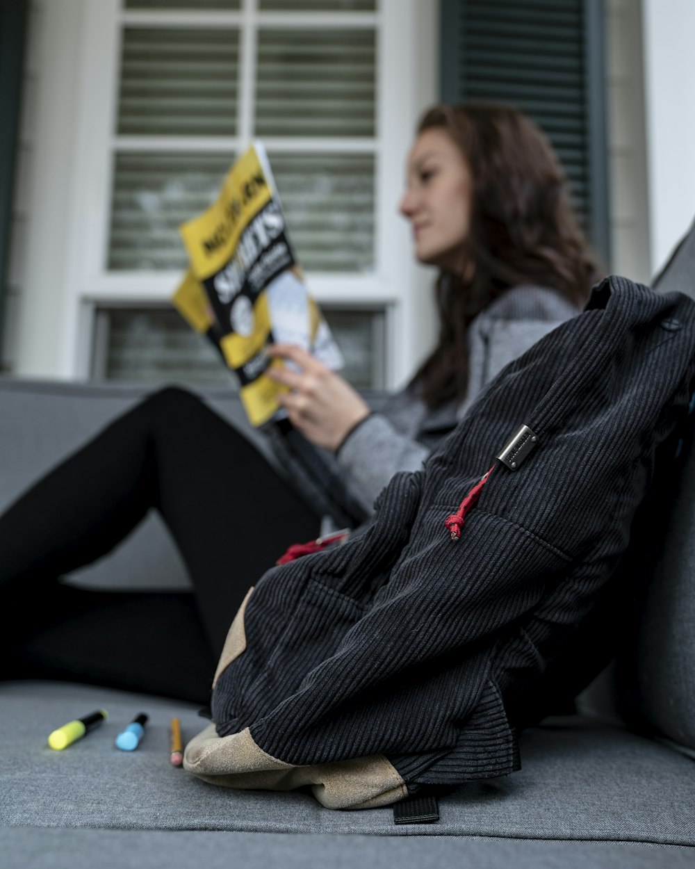 Photo de mise au point peu profonde de dos noir près d’une femme lisant un magazine