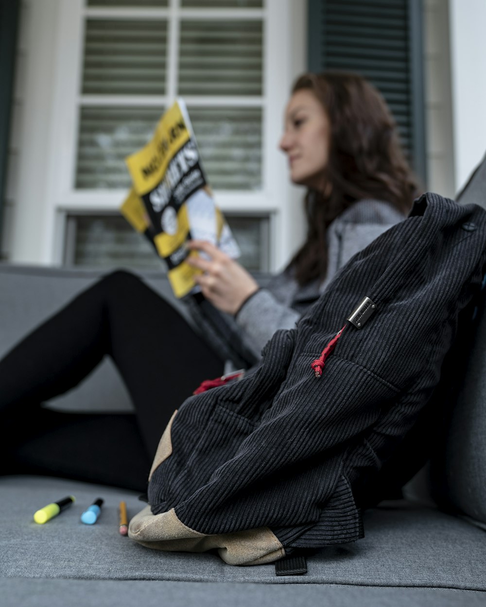 shallow focus photo of black back near woman reading magazine