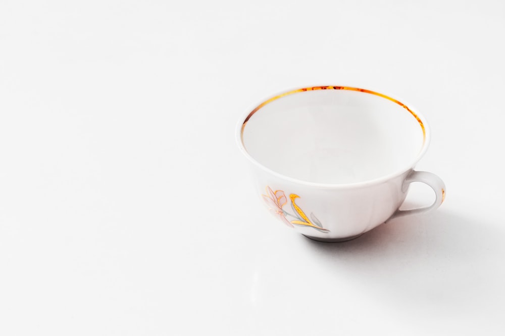 white and yellow ceramic cup