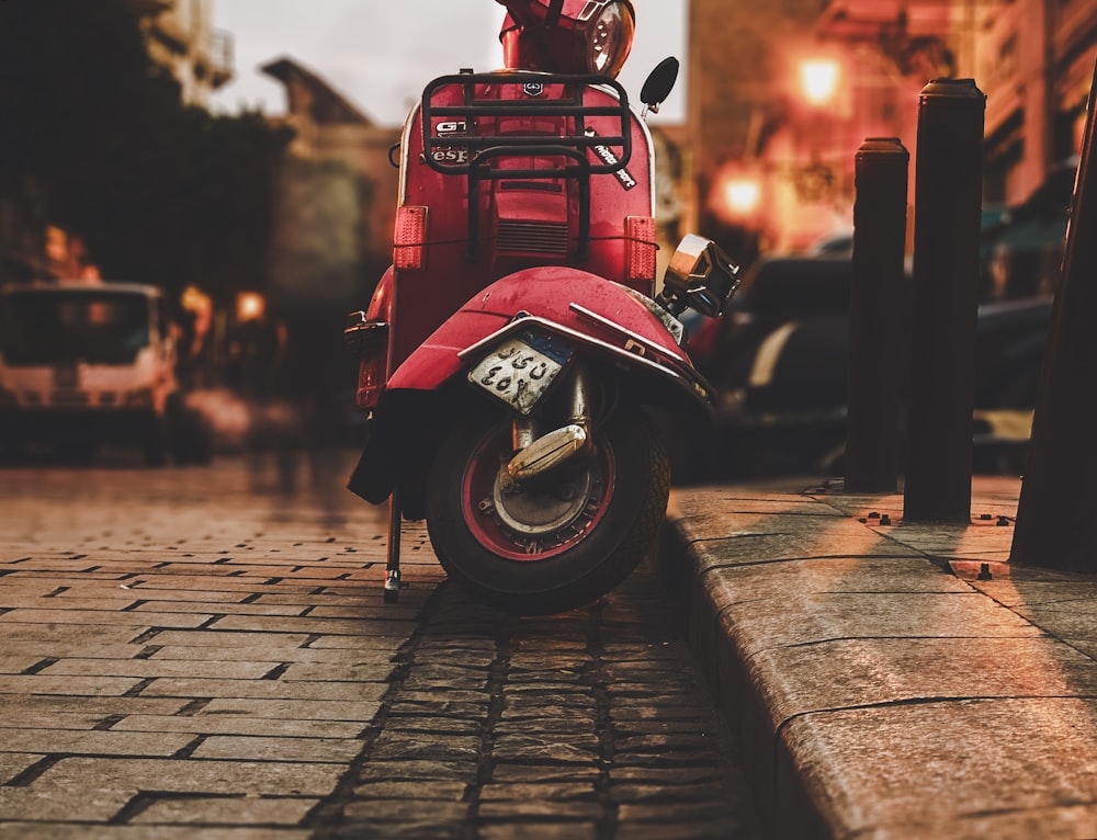 red automatic scooter parking on street during day time