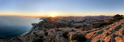 A panoramic view of Rabat's coastline with the Atlantic Ocean meeting the cityscape at sunset.
