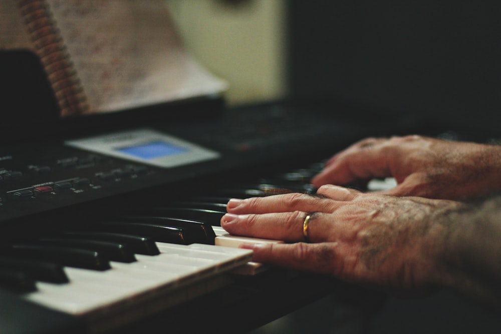 shallow focus photo of person playing piano