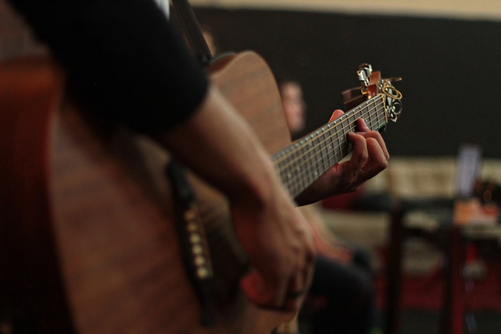 person playing acoustic guitar