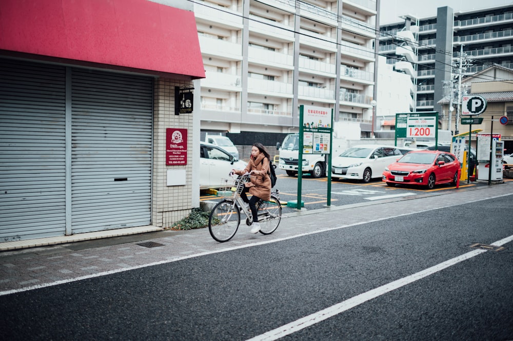 日中にアスファルト道路を走るシティバイクに乗る女性