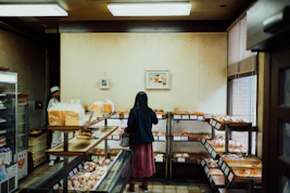 A friendly marketing consultant discussing website design with a local bakery owner in a bright, cozy shop.
