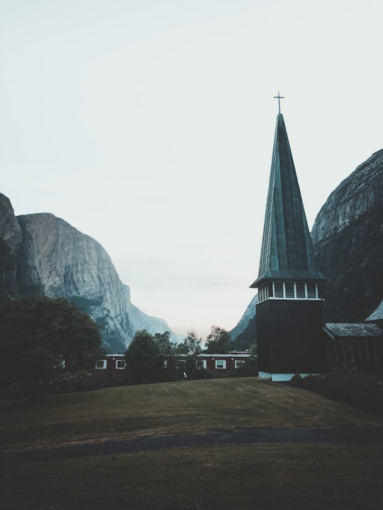 grey stone buttes looming behind cathedral in Lysebotn Norway