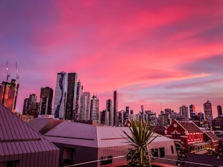 A modern city skyline at sunset highlighting commercial and residential buildings.