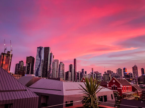A modern city skyline at sunset highlighting diverse residential and mixed-use buildings.