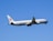An airplane with Air China livery is flying against a clear blue sky. The aircraft's wings and tail are visible, with engines mounted under each wing. The plane is in ascent as indicated by its upward angle.