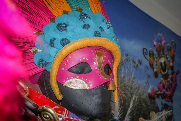 A vibrant carnival mask with colorful feathers and intricate beadwork.
