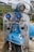 A vintage scooter with a predominantly blue and white color scheme, featuring various decorative elements including a small Italian flag decal, pin-up style artwork, and multiple chrome accessories. It has two blue auxiliary lights, a rearview mirror, and brand logos.