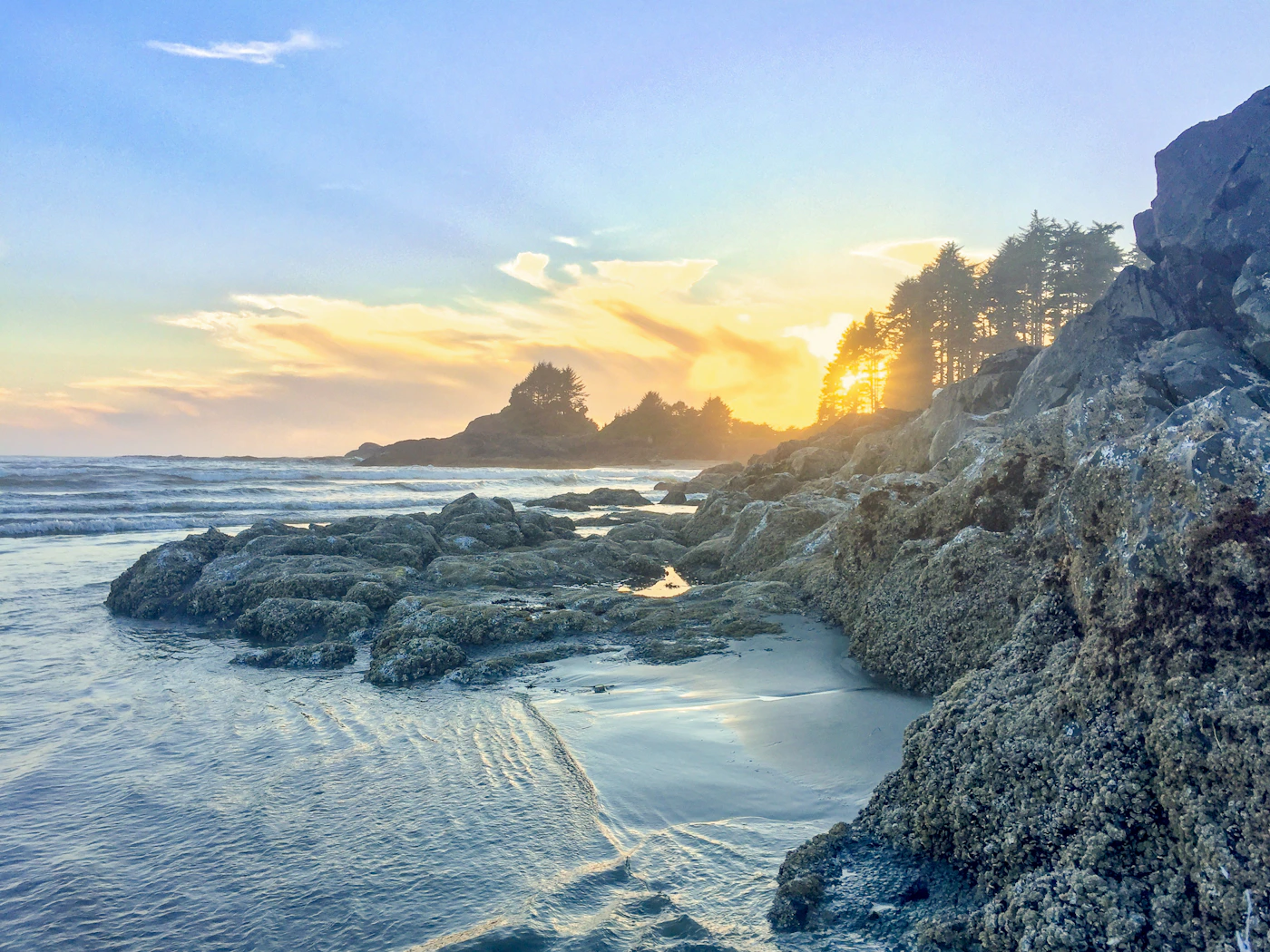 Rocky Tofino shoreline with Pacific Ocean waves crashing against the rocks in evening light