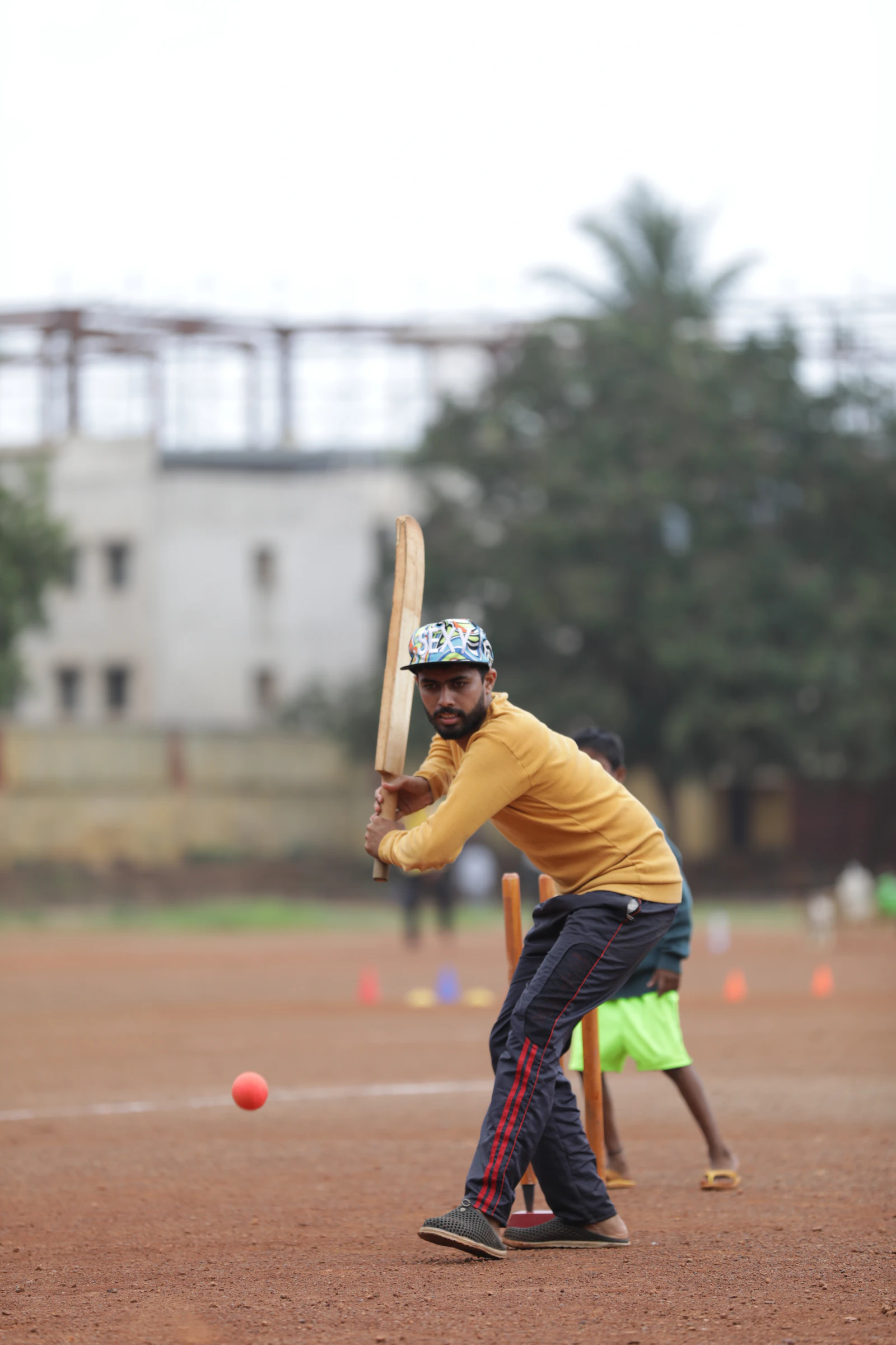 Coach holding a cricket bat on the field