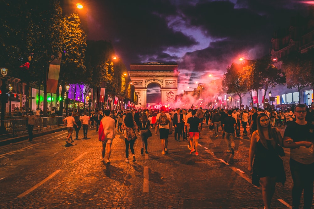 people walking on road at night time