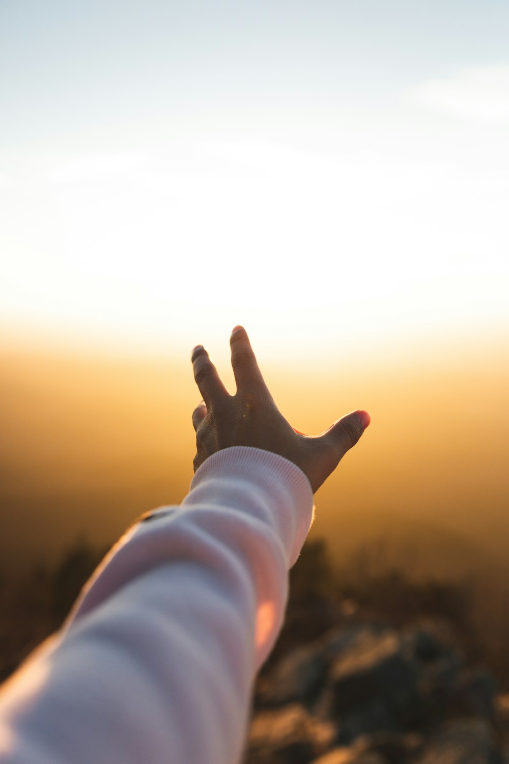 Die linke Hand der Person fängt Sonnenlicht