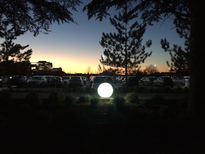 A commercial site featuring bright pole lighting illuminating a parking lot at dusk.