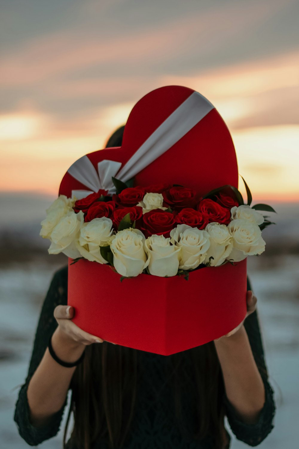 person holding box of roses