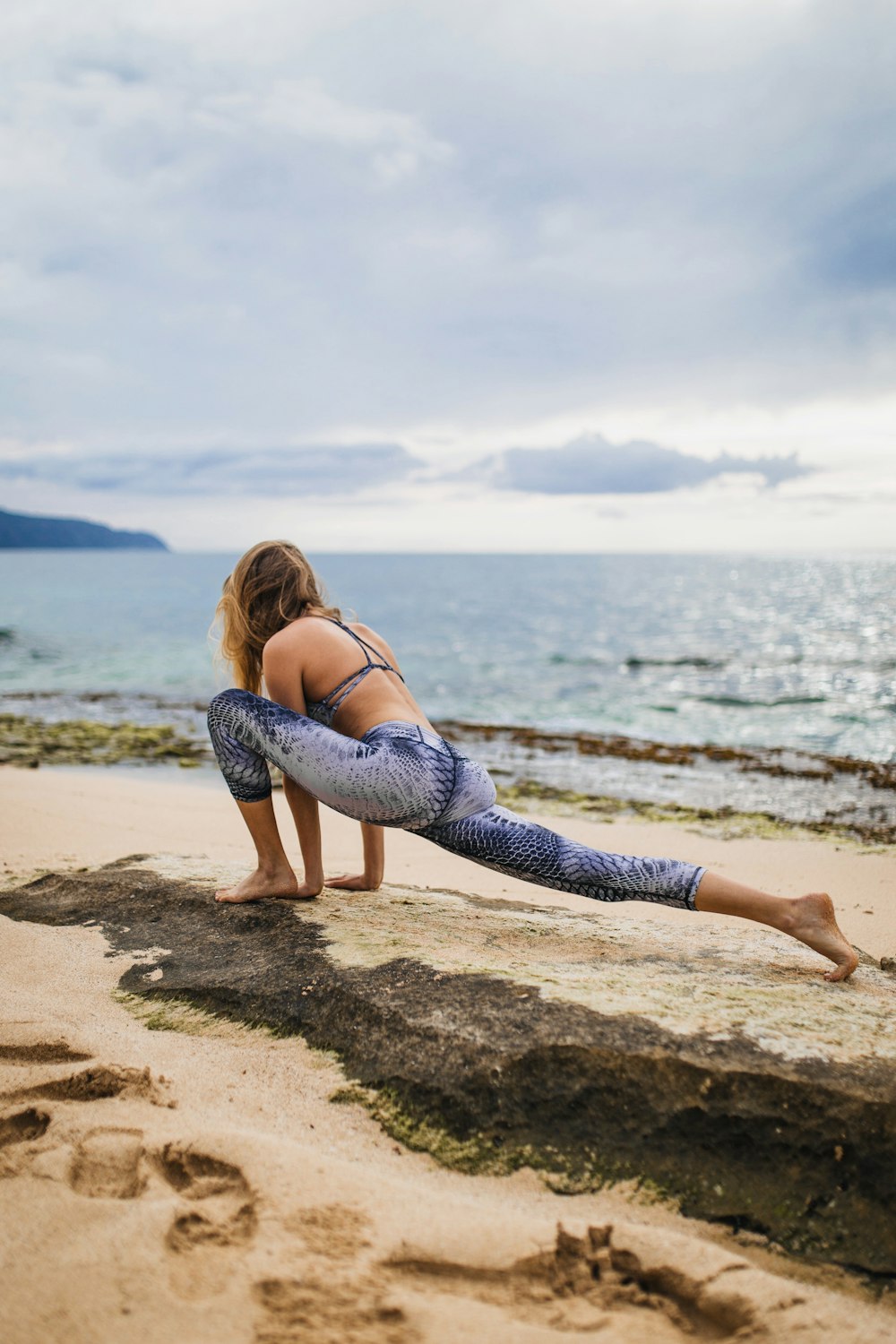 woman stretching beside body of water