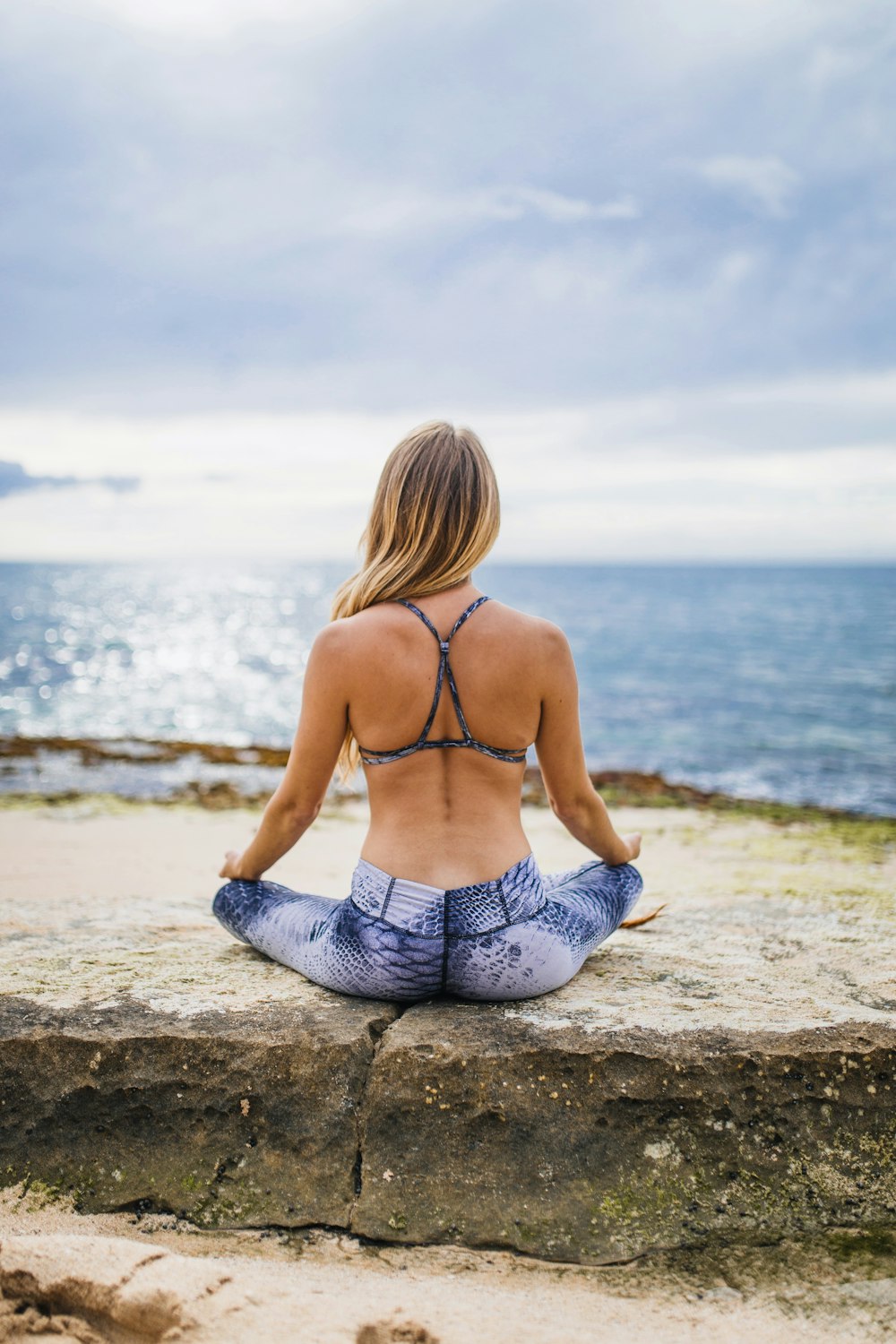 woman meditating front of sea at daytime