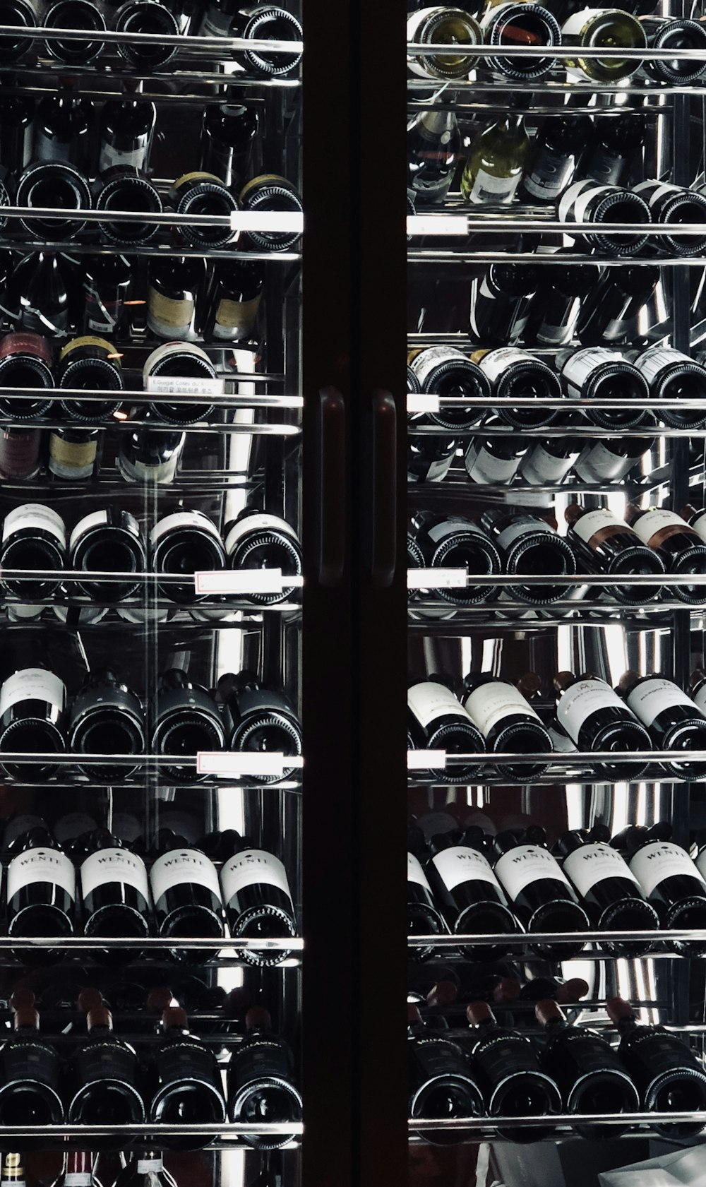 close-up photography of wine bottles on stainless steel rack