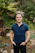 A stylish man wearing a navy blue Leovotom polo shirt, smiling confidently outdoors.