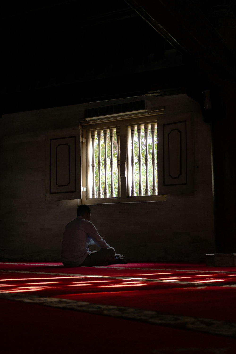 man sitting in front of window