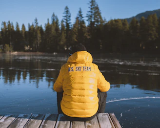 Coach giving personalized advice to a triathlete beside a lake with snow-capped peaks behind.