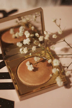 Soft-focus image of a sleek black and gold cosmetic compact with a subtle glow