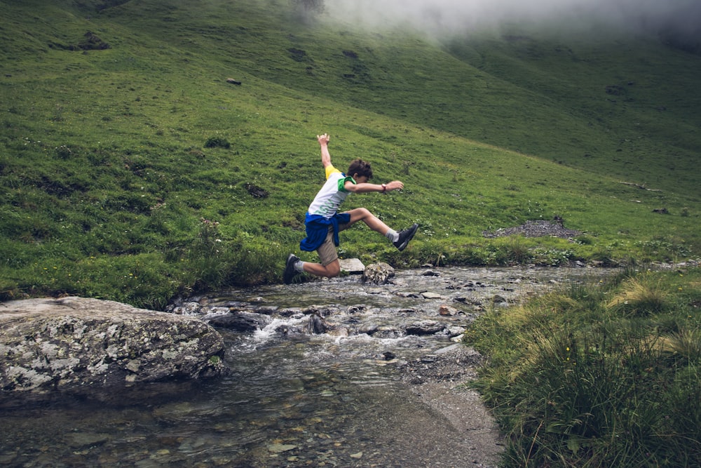 child leaping over stream photo