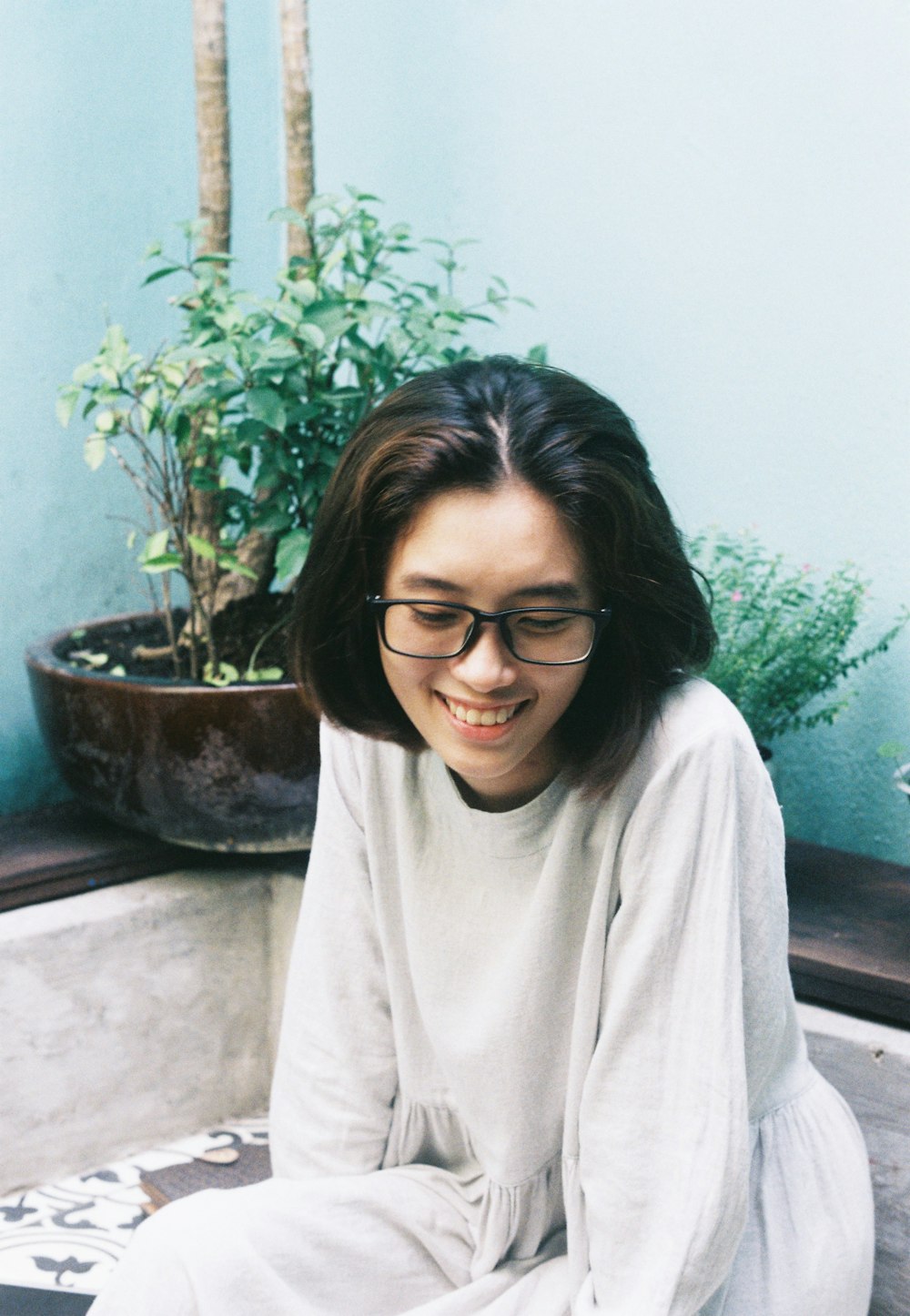 woman sitting while looking down and smiling