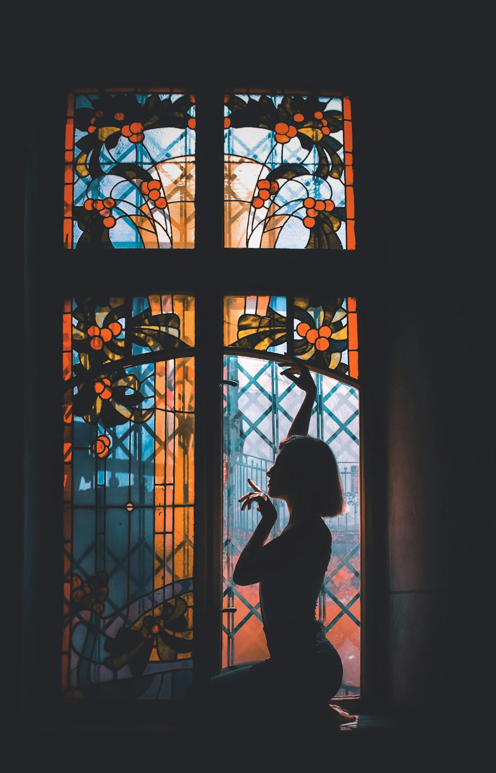 silhouette of woman sitting beside window