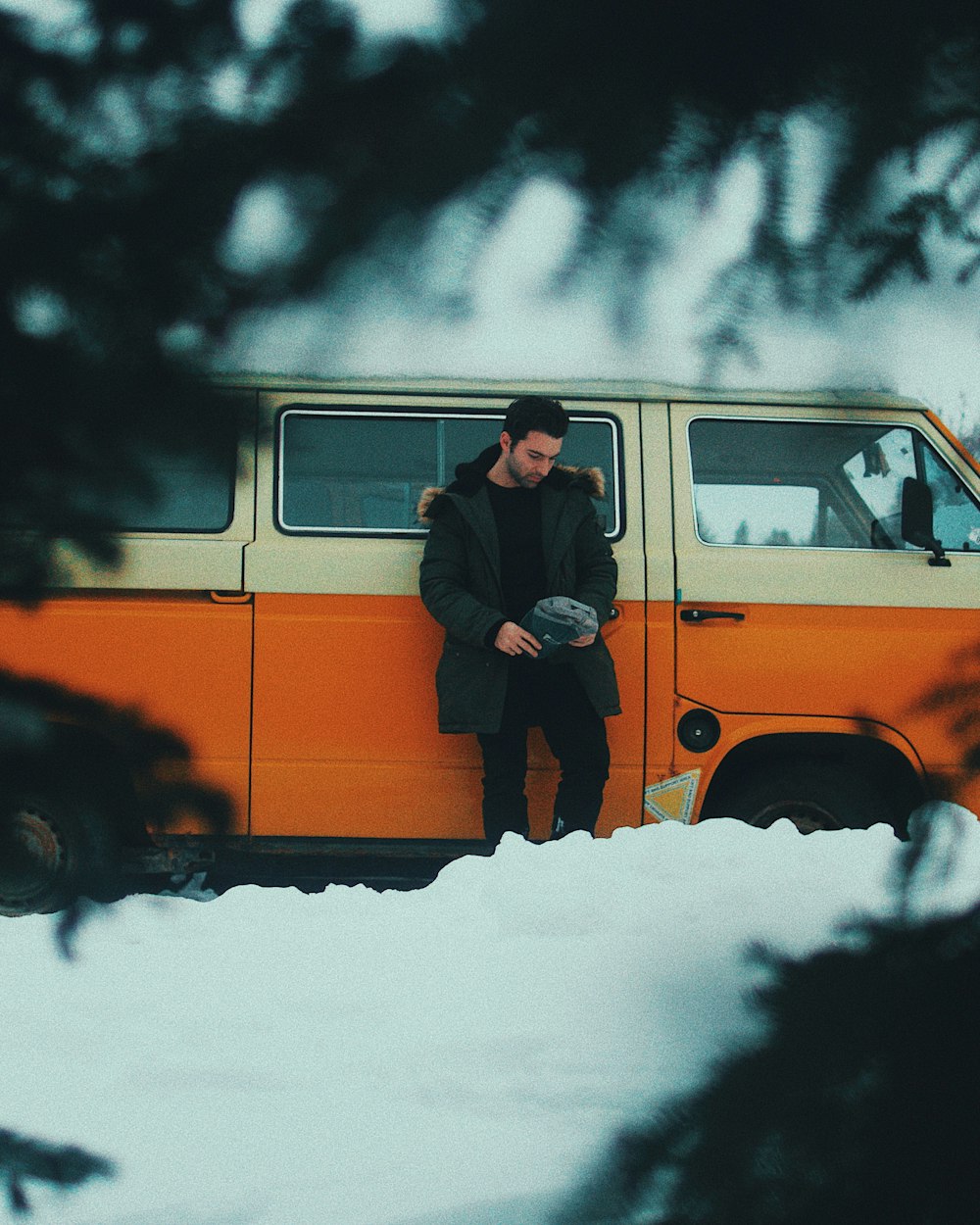 man leaning on orange and white van