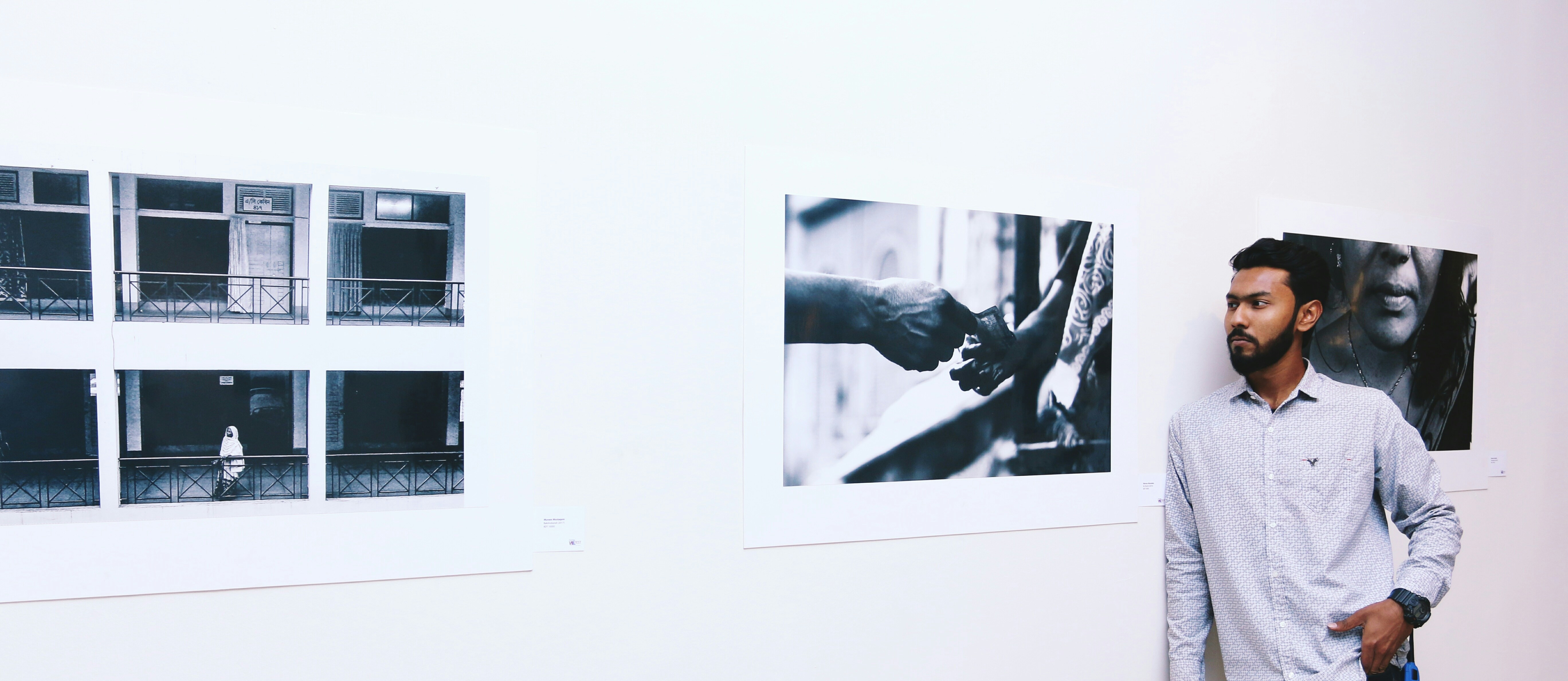 man in white dress shirt standing beside wall