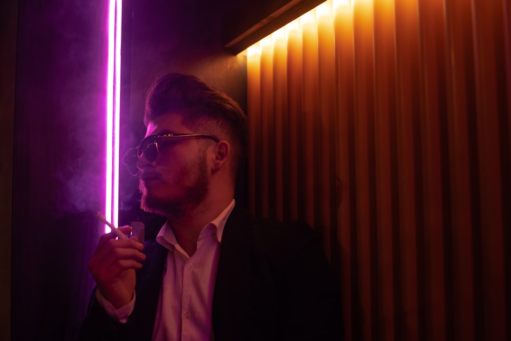 man in black suit jacket smoking cigarette