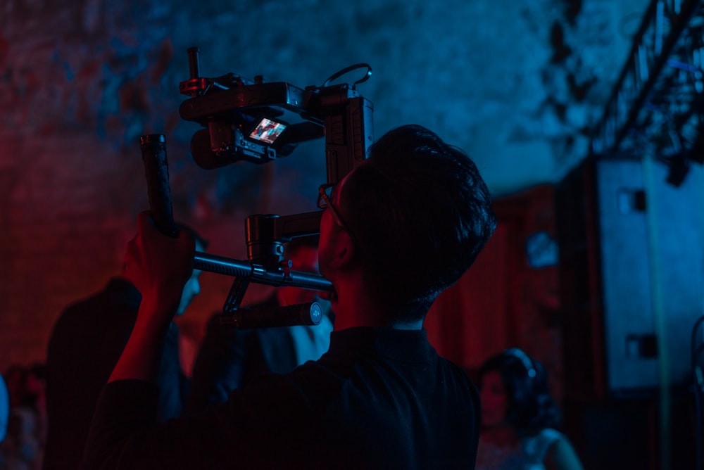 man holds camera near man in suit in room