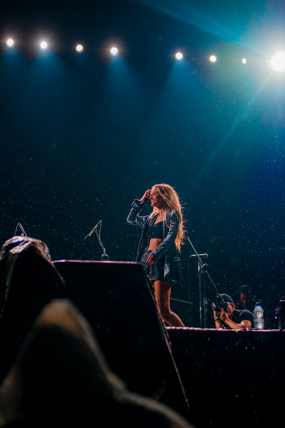 Donna in top blu in piedi sul palco