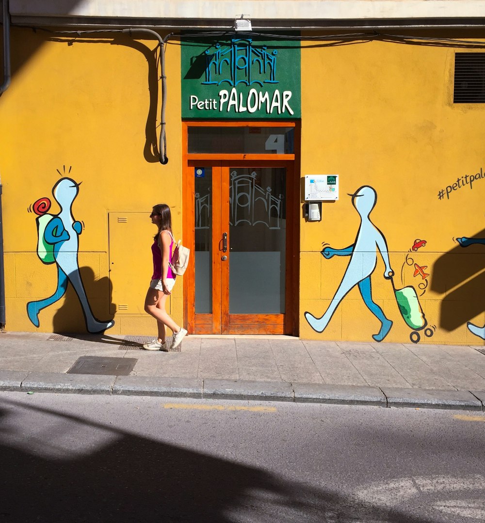 woman walking on sidewalk near Petit Palomar building